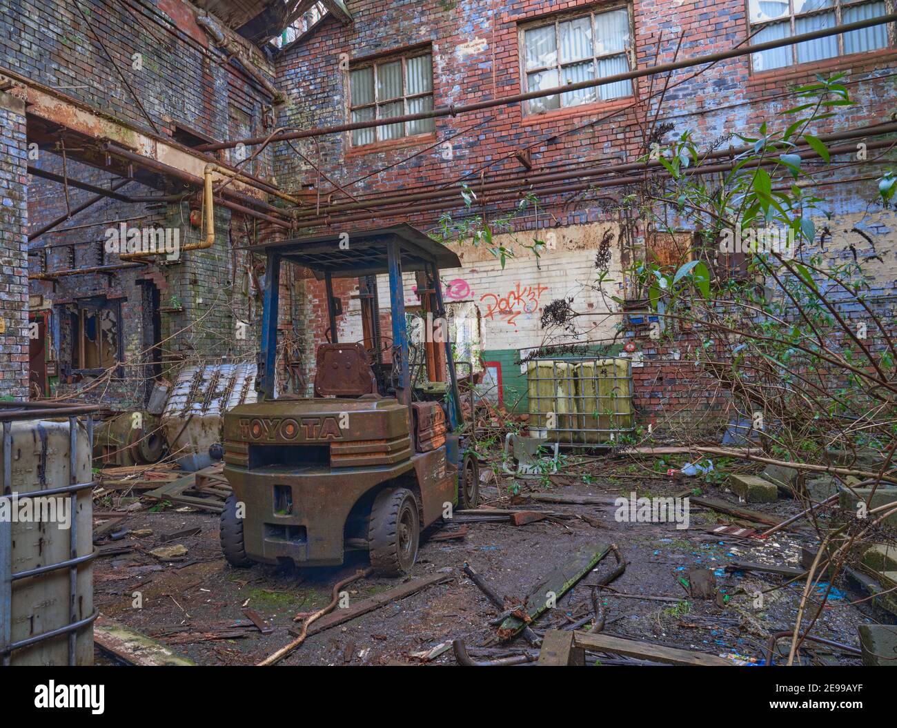 Vecchio carrello impilatore arrugginito abbandonato in un vecchio magazzino Foto Stock