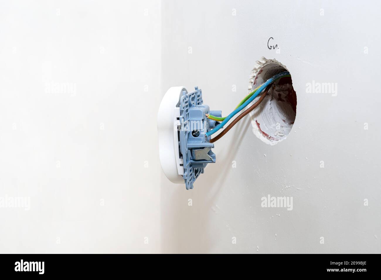 Doppia presa elettrica che sporge dalla parete, che si fissa ai cavi elettrici. Foto Stock