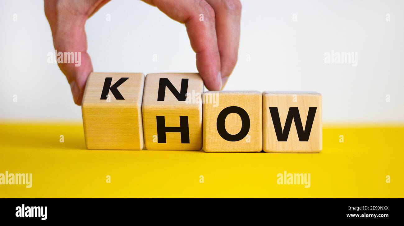 Conoscere il simbolo. L'uomo d'affari gira i cubi e cambia la parola 'come' a 'sapere'. Bel tavolo giallo, sfondo bianco. Spazio di copia. Business e know Foto Stock