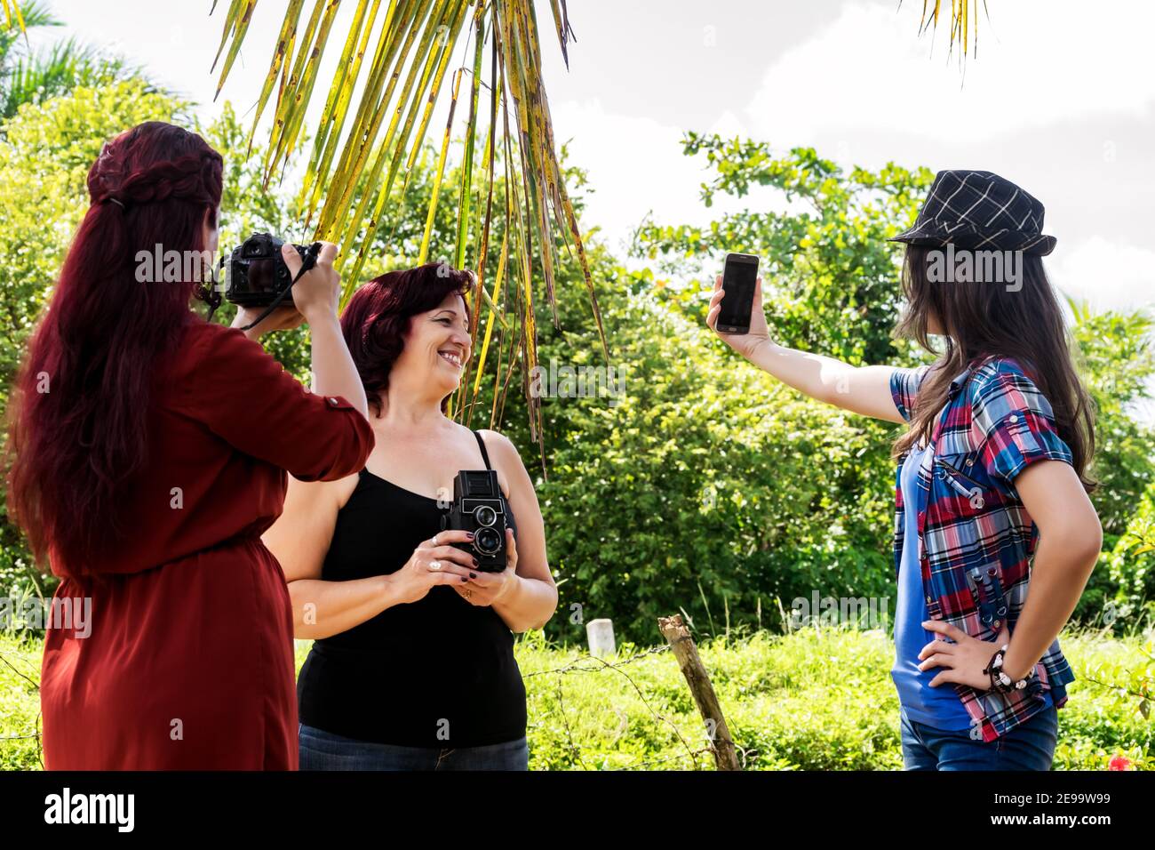 Tre fotografi cubani cresciuti di diverse generazioni immagini all'aperto insieme, uno di loro sta scattando un selfie Foto Stock