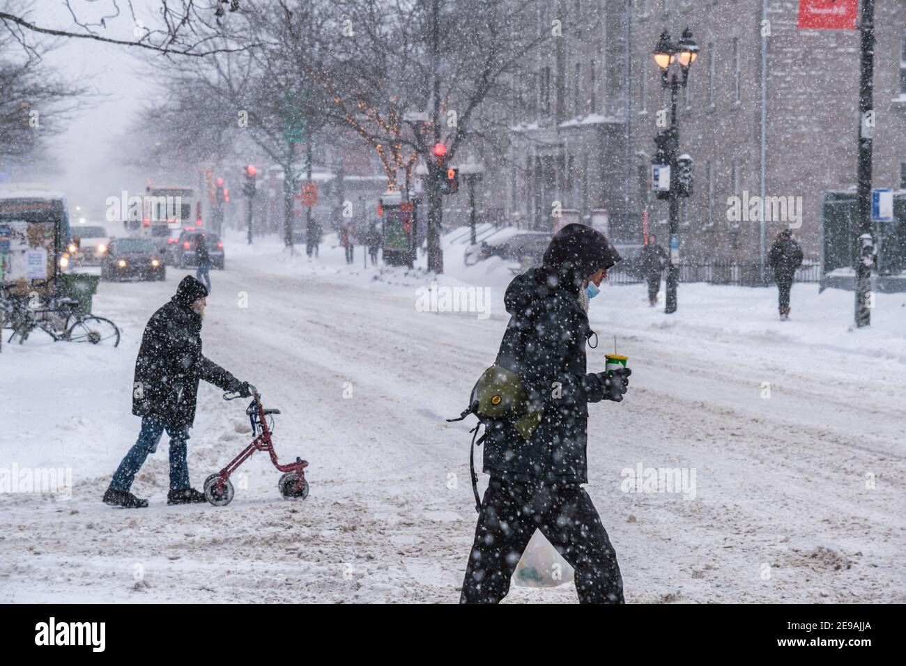 Montreal, CA - 2 febbraio 2021: Persone con maschere protettive che camminano per strada durante una forte nevicata Foto Stock