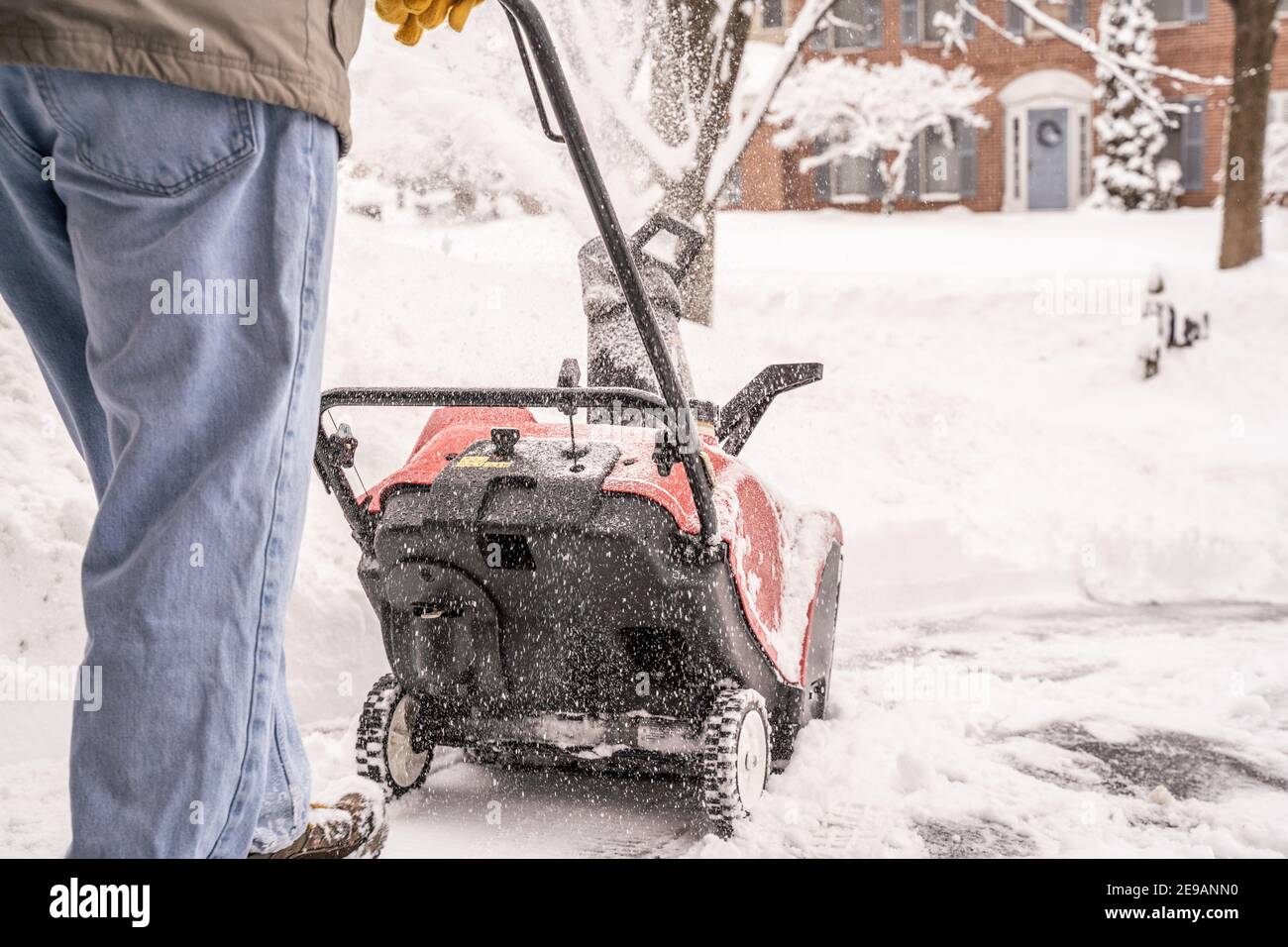 Berks County, Pennsylvania-2 febbraio 2021: Uomo anziano che usa un soffiatore di neve per liberare il marciapiede e il vialetto dopo la tempesta di neve Foto Stock