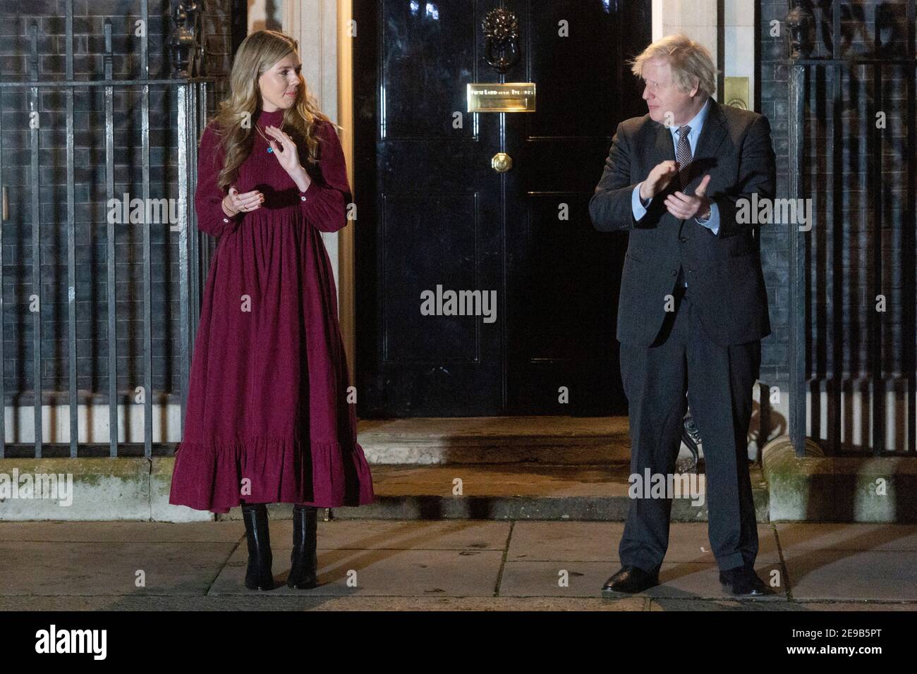 03 febbraio 2021. Londra, Regno Unito. Il primo ministro britannico Boris Johnson e il suo partner Carrie Symonds si sono aggrappati alle porte di 10 Downing Street per onorare il capitano Tom Moore. Johnson ha incoraggiato la popolazione della Gran Bretagna a partecipare ad un clap pubblico più tardi questa sera, in riconoscimento del famoso servizio sanitario di beneficenza Raiser Captain Tom che è morto Martedì. Foto di Ray Tang. Foto Stock