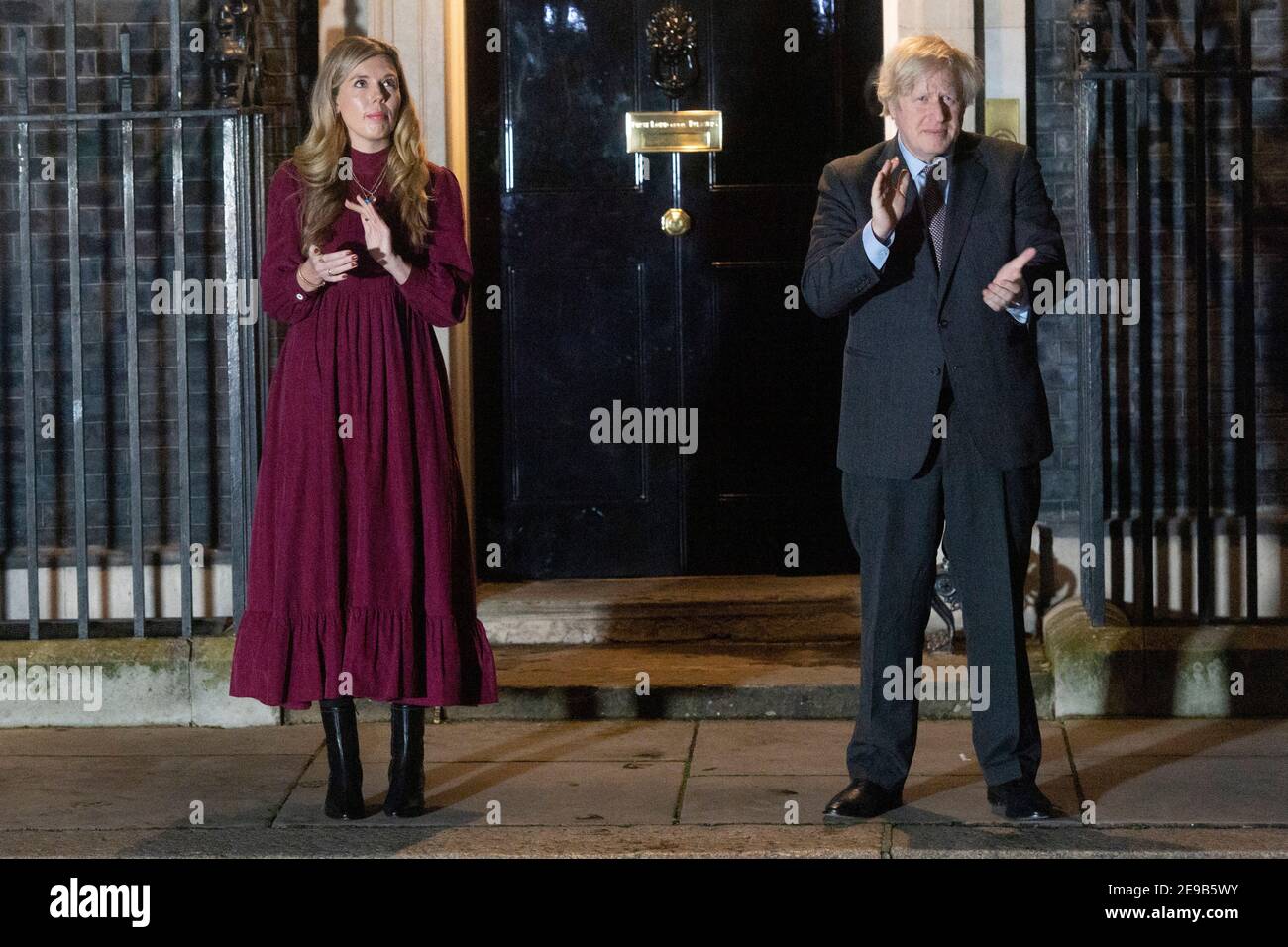 03 febbraio 2021. Londra, Regno Unito. Il primo ministro britannico Boris Johnson e il suo partner Carrie Symonds si sono aggrappati alle porte di 10 Downing Street per onorare il capitano Tom Moore. Johnson ha incoraggiato la popolazione della Gran Bretagna a partecipare ad un clap pubblico più tardi questa sera, in riconoscimento del famoso servizio sanitario di beneficenza Raiser Captain Tom che è morto Martedì. Foto di Ray Tang. Foto Stock