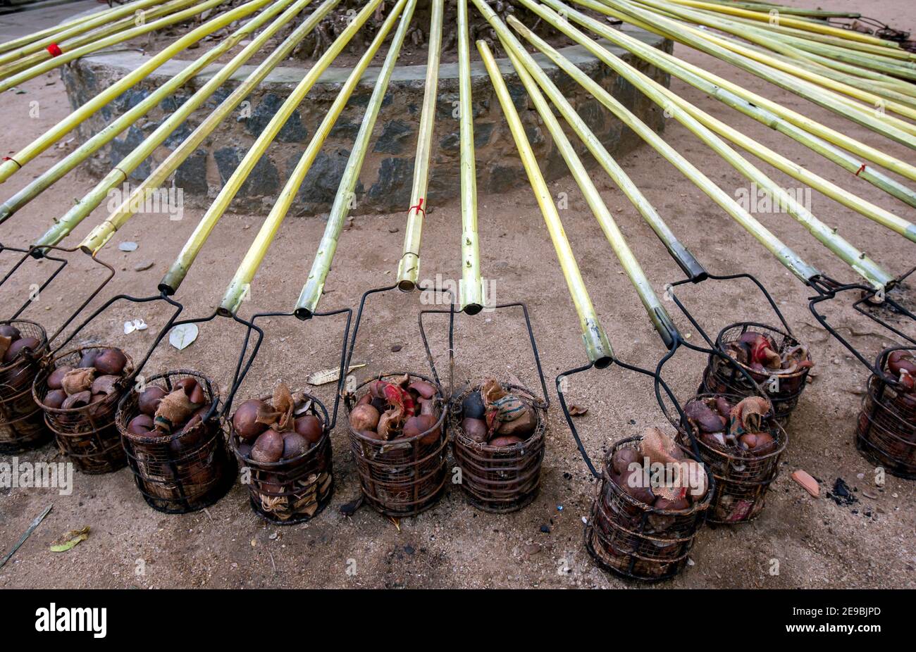 Cestelli in acciaio riempiti di conchiglie di cocco e portati su pali pronti per essere portati in luce durante il buddista Esala Perahera a Kandy in Sri Lanka. Foto Stock