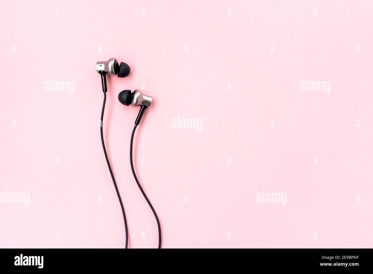 Coppia di auricolari neri per smartphone su sfondo rosa. Piatto  minimalista. Luogo per la scrittura. Spazio di copia. Sfondo creativo Foto  stock - Alamy