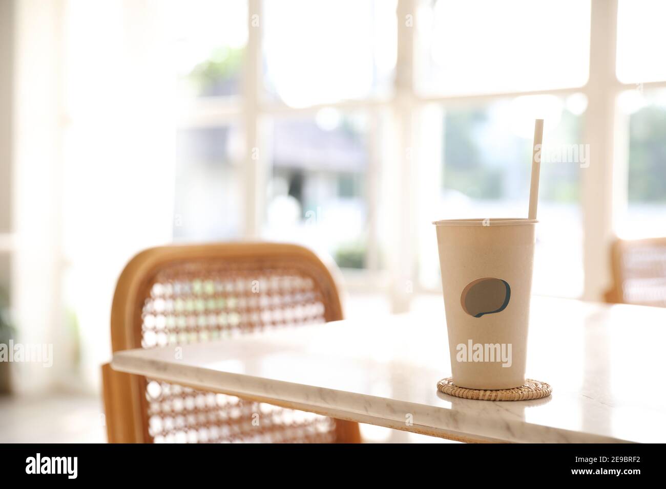 Caffè ghiacciato con vetro di carta sullo sfondo della caffetteria Foto Stock