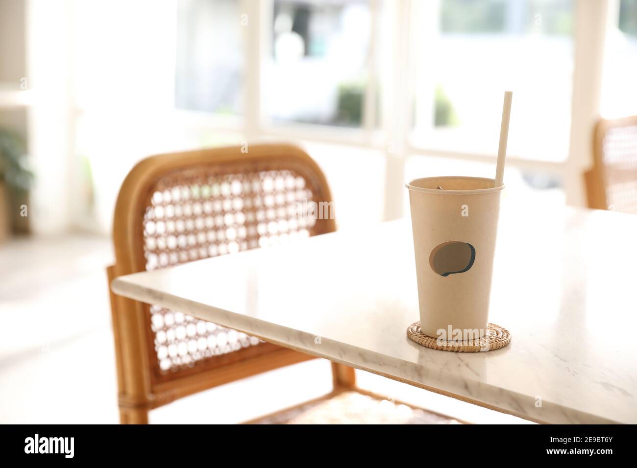 Caffè ghiacciato con vetro di carta sullo sfondo della caffetteria Foto Stock