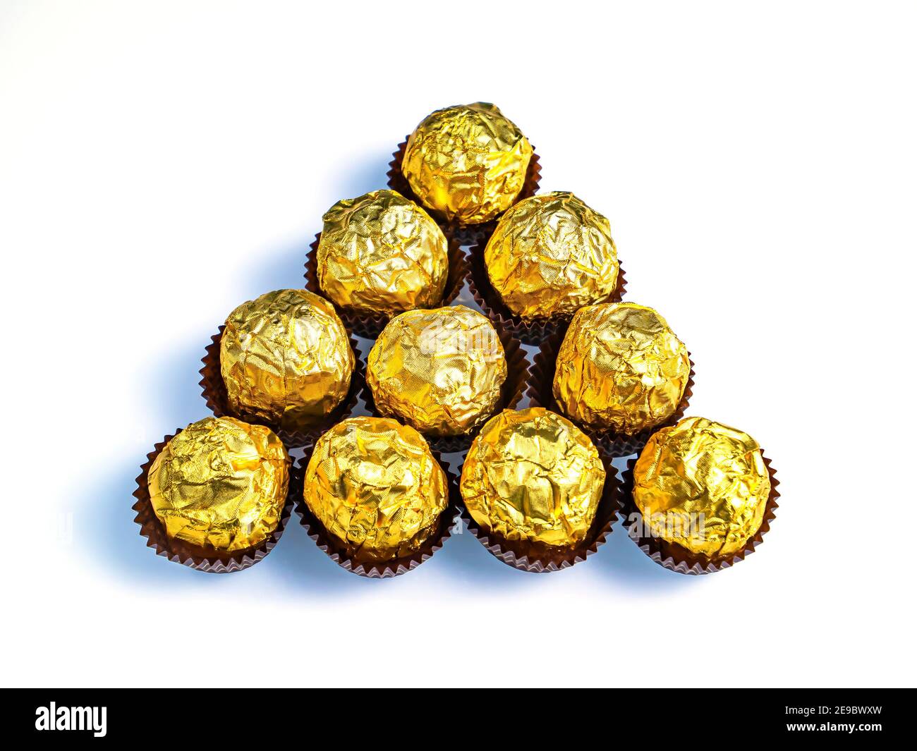 Caramelle di cioccolato rotonde in un involucro di lamina dorata su sfondo  bianco. Dolce torta. Wrapper dorato. Lamina lucida. Involucro di caramella.  Dolce dessert. Bianco ba Foto stock - Alamy