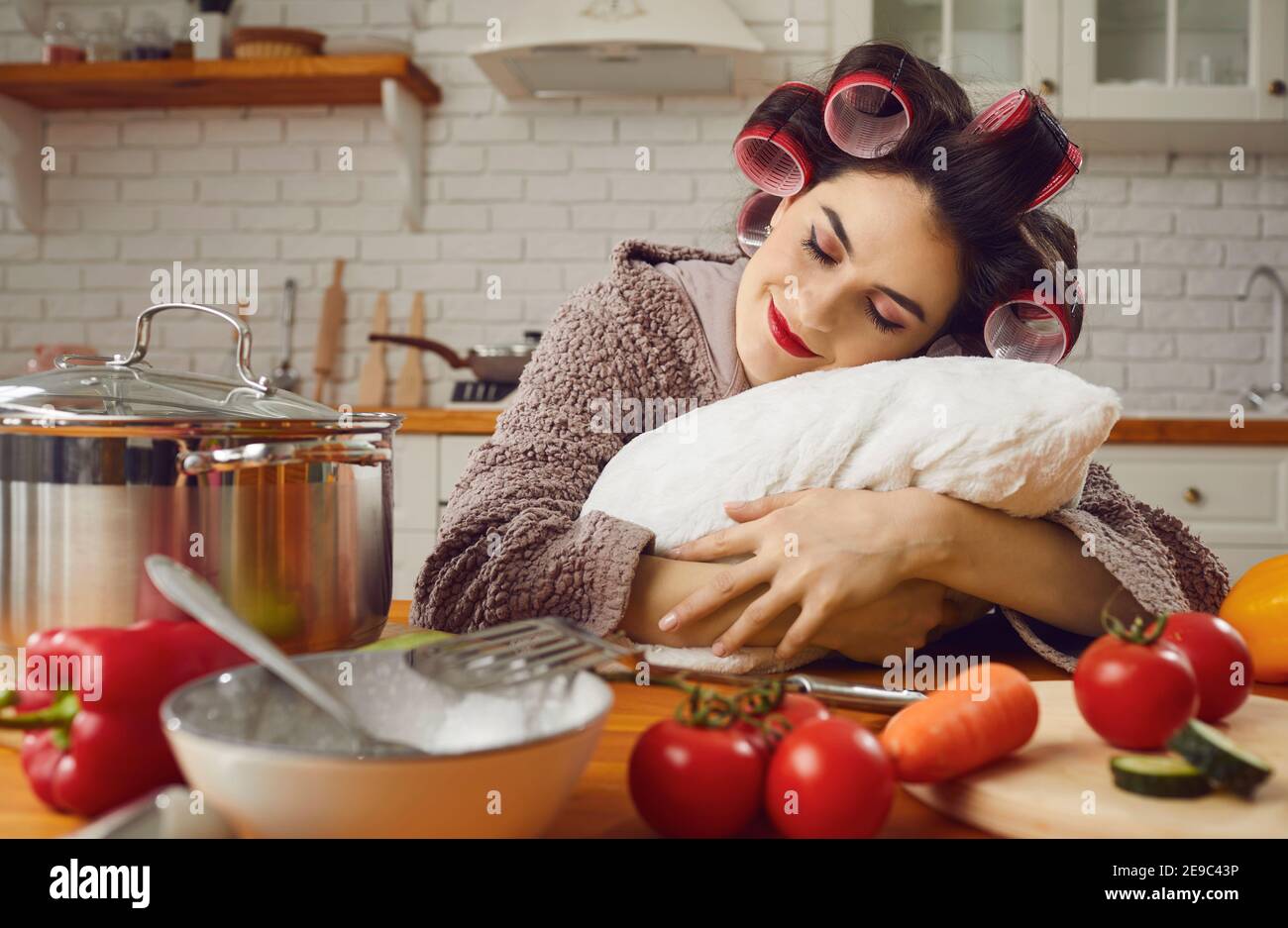 Stanco o semplicemente pigro giovane casalinga che prende un pisolino e. sognare tra cucinare un pasto Foto Stock