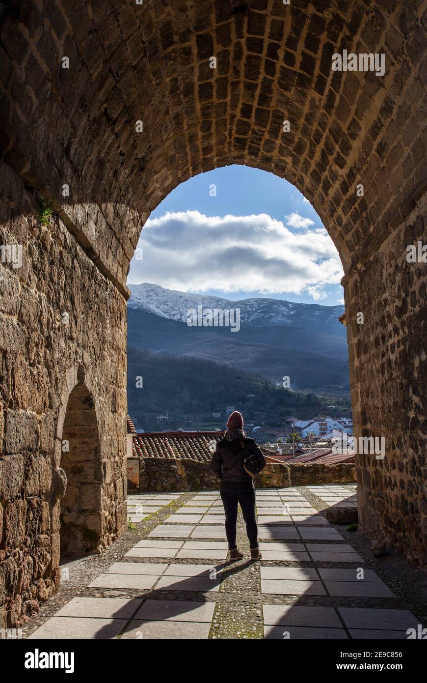 Visitatore sotto l'arco della Chiesa di Santa Maria, Ambroz villaggio valle. Caceres, Estremadura, Spagna. Foto Stock