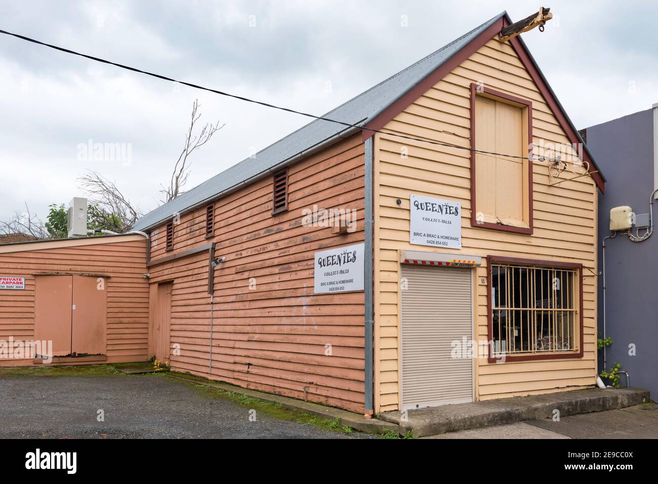 Un piccolo capannone di legno o ex magazzino e negozio di fronte a West Market Street, Richmond, New South Wales con porte di livello superiore e un legno pully. Foto Stock