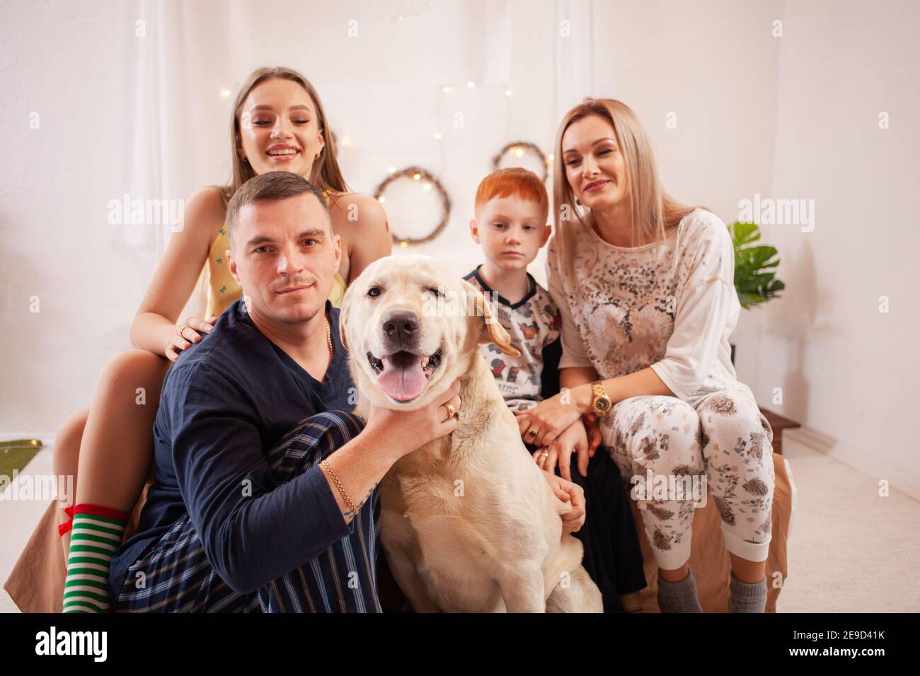 Felice famiglia in pigiama sul letto. Papà, figlio di mamma e figlia  sorridono. Labrador cane Foto stock - Alamy