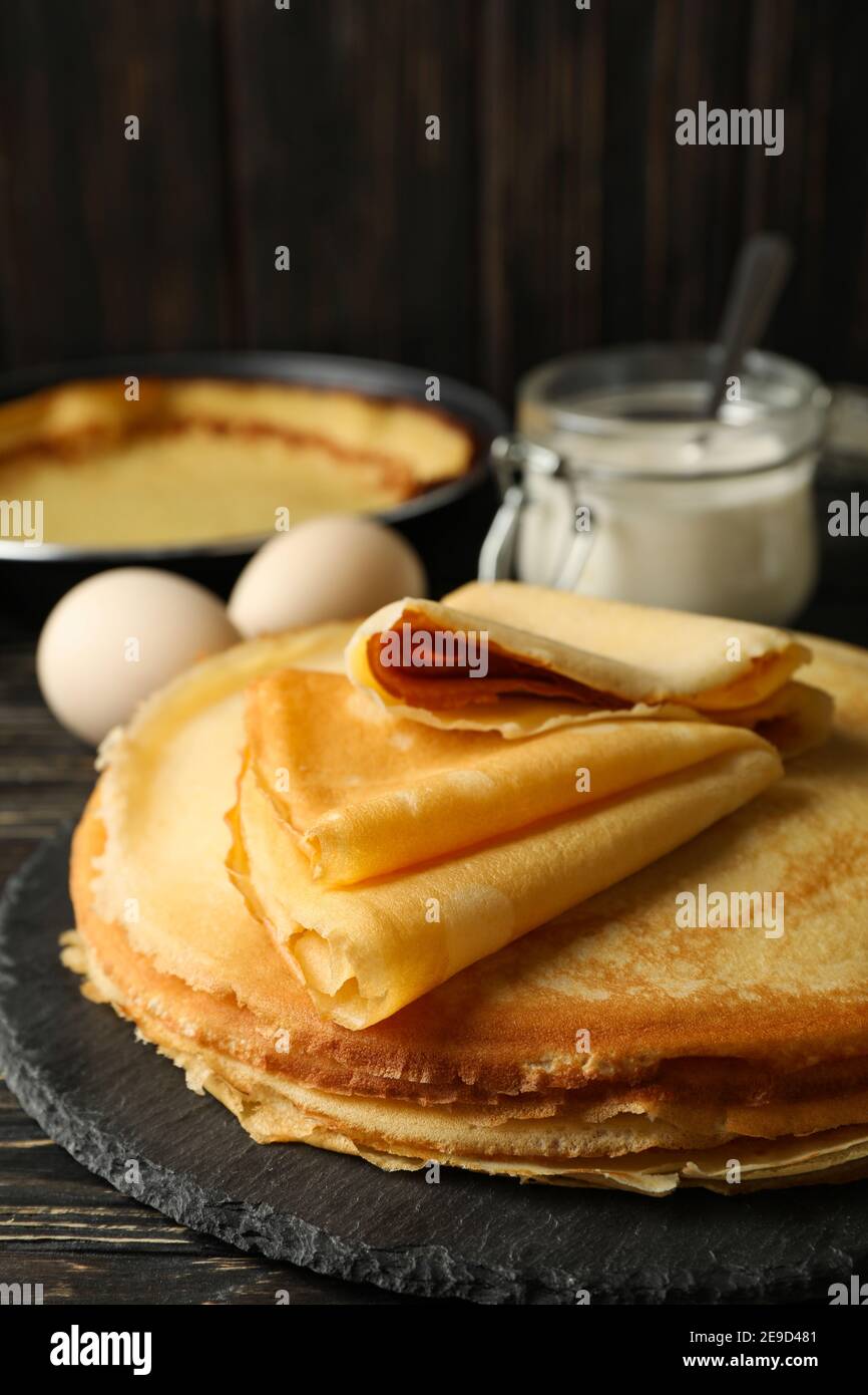 Concetto di gustosa colazione con sottili pancake su tavolo di legno Foto Stock