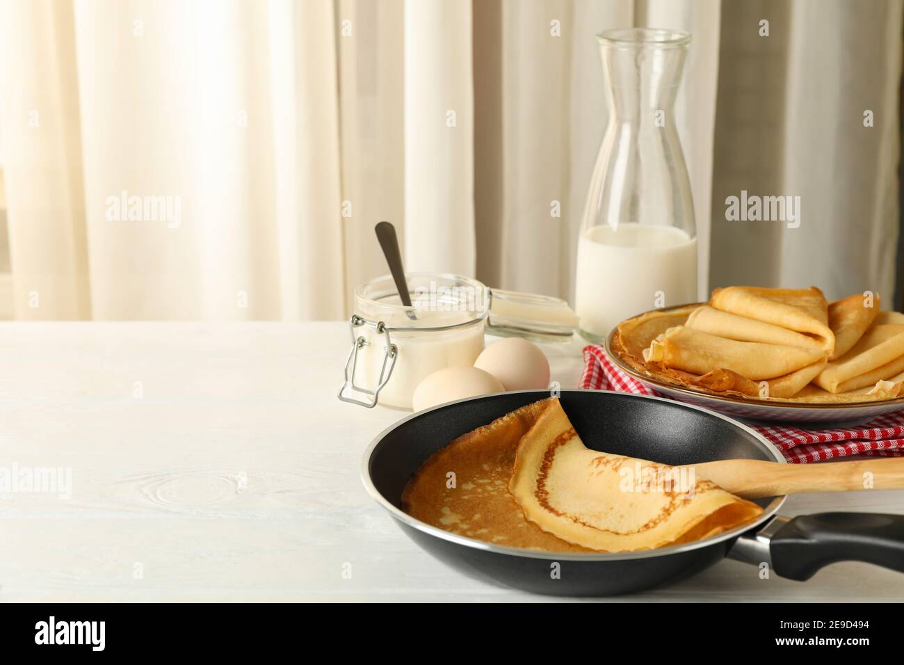Concetto di gustosa colazione con sottili frittelle su legno bianco tabella Foto Stock