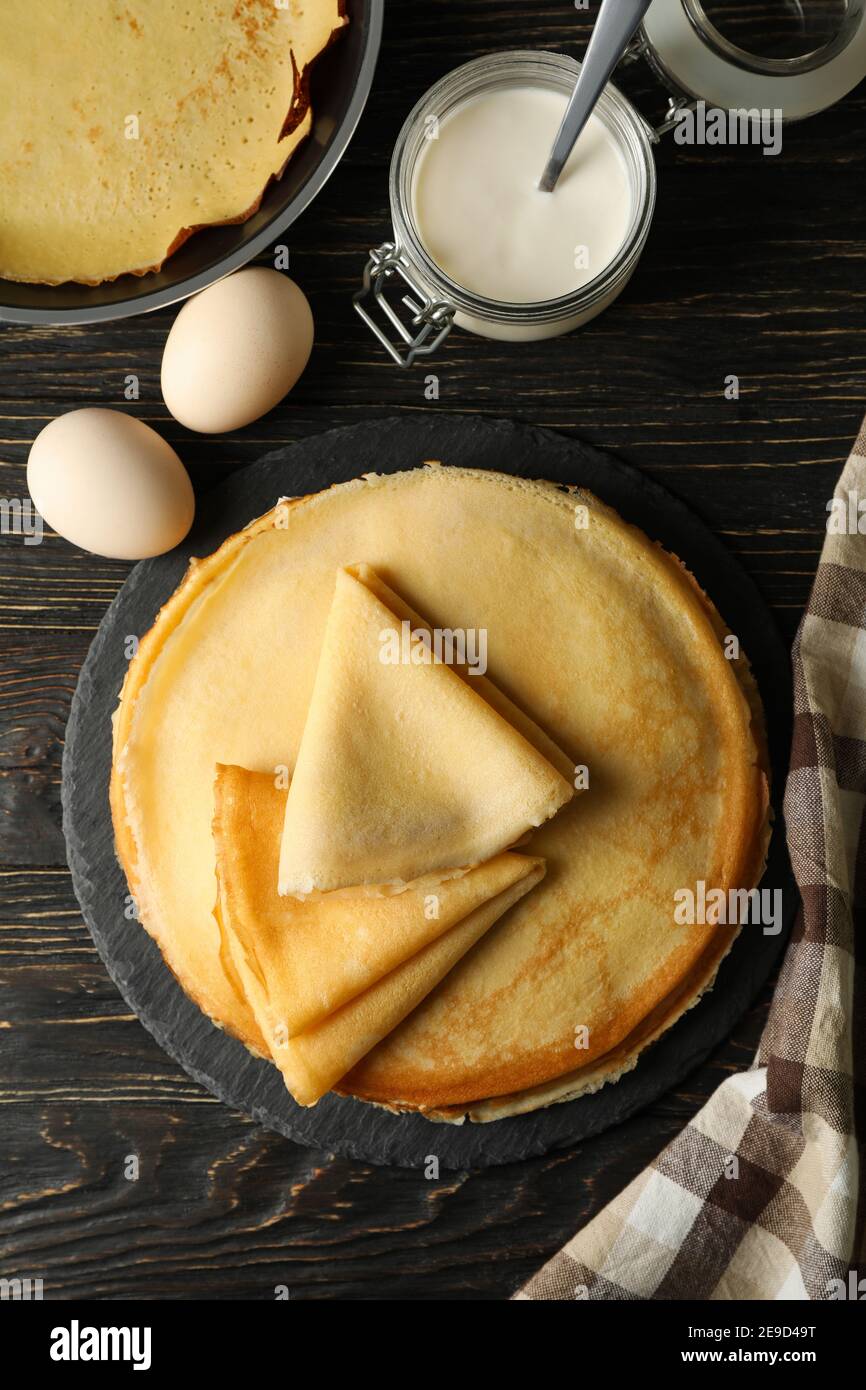 Concetto di gustosa colazione con sottili pancake su tavolo di legno Foto Stock