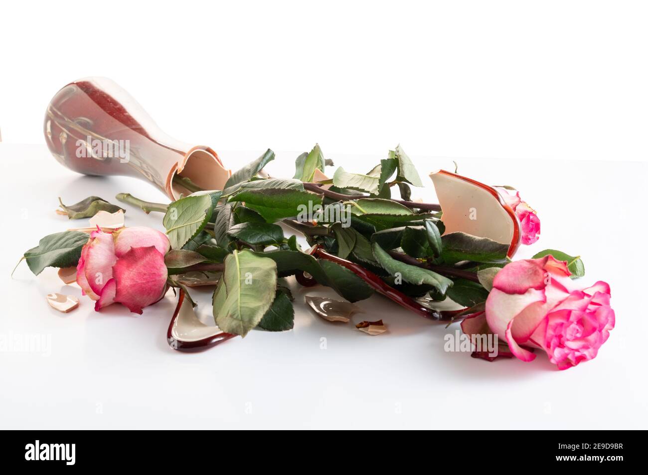 Un bouquet di rose in un vaso rotto. Fiori rovinati in un vaso. Bouquet rotto di rose in un vaso. Vista angolare. Foto Stock