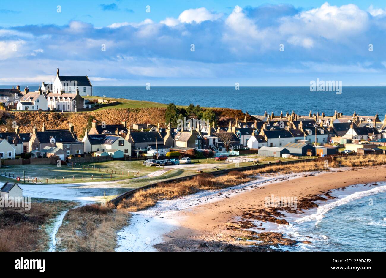 FINDOCHTY MORAY COSTA SCOZIA GELATA MATTINA UNA CHIESA SUL HILL VILLAGE CASE E LA BAIA CON NEVE SUL SPIAGGIA Foto Stock