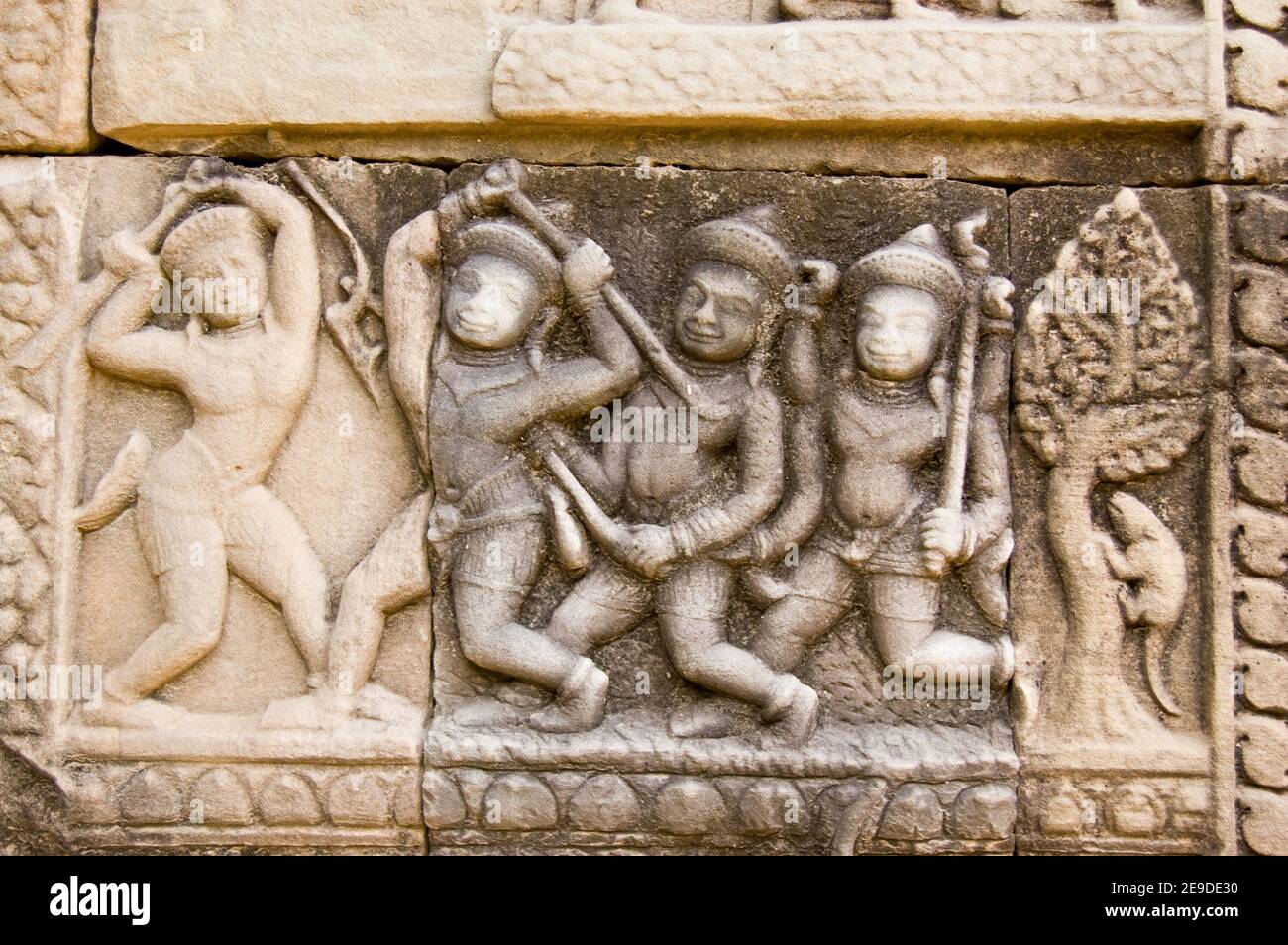 Antico fregio di bassorilievo Khmer che mostra uomini che combattono con bastoni. Tempio di Baphuon, Angkor, Cambogia. Scultura antica, di centinaia di anni. Foto Stock
