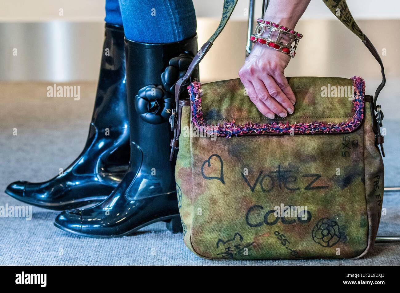 Londra, Regno Unito. 4 Feb 2021. Stivali Wellington firmati da Chanel con  design Camellia (parte di un set di 2 paia) est £200-300 con Graffiti sui  marciapiedi Borsa Messenger, primavera 2015, tela