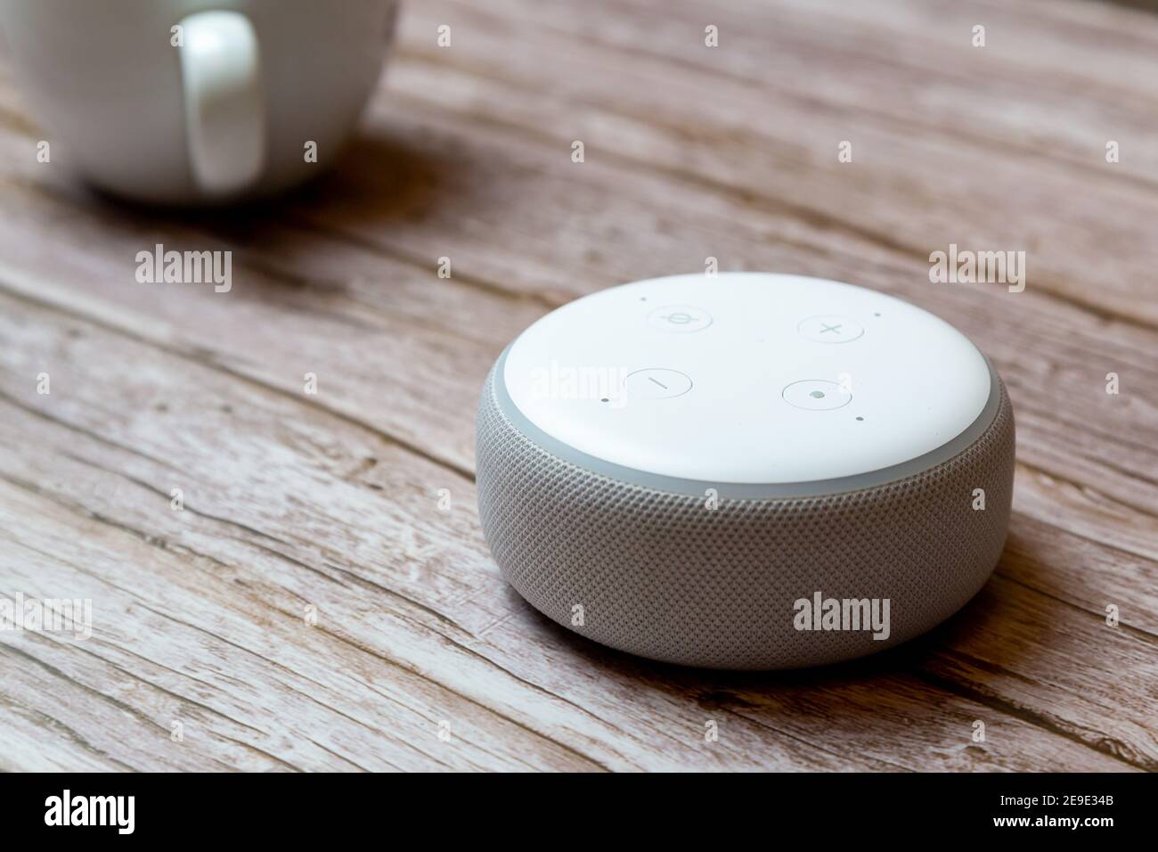 Un punto Amazon Echo o un dispositivo amazon Alexa isolato su un tavolo o una scrivania in legno Foto Stock