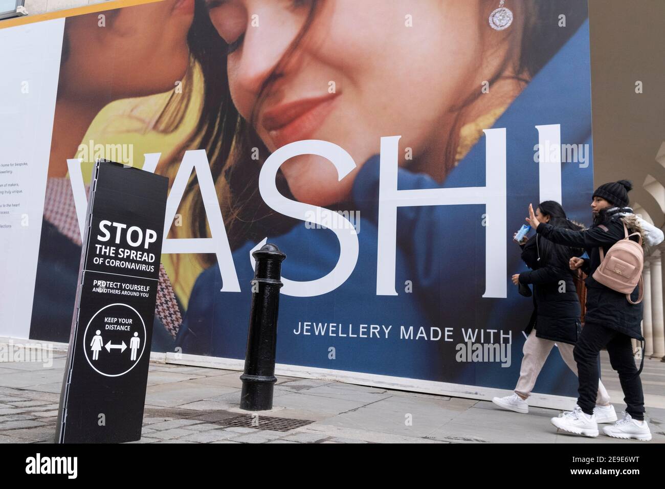 Un cartellone per il rivenditore di gioielli Vashi copre il loro esterno Covent Garden, dietro cartelli che esortano i londinesi ad osservare le regole della distanza sociale di Covid durante il terzo blocco della pandemia di Coronavirus, il 2 febbraio 2021, a Londra, Inghilterra. Foto Stock