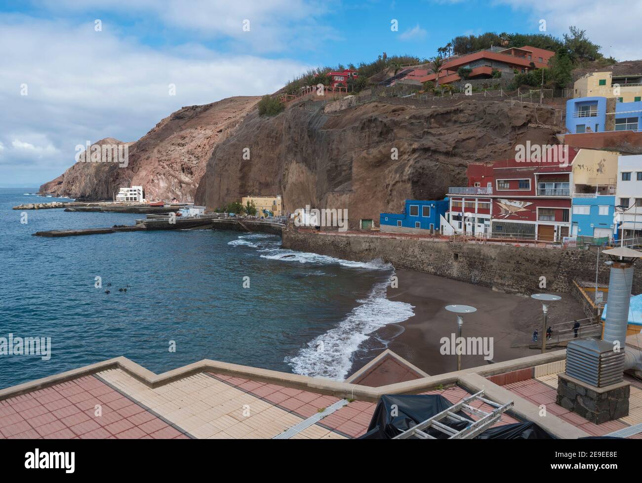 Vista del villaggio Puerto de Sardina del Norte con spiaggia di sabbia, scogliere costiere, porticciolo e case colorate. Grand Canaria, Isole Canarie, Spagna Foto Stock