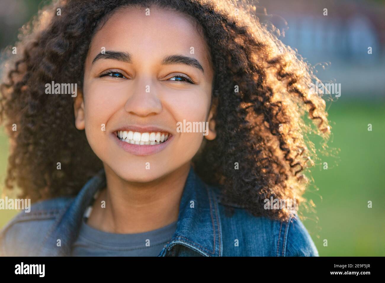 Outdoor ritratto della bella felice razza mista americano africano ragazza adolescente femmine giovane donna sorridente con denti perfetti Foto Stock