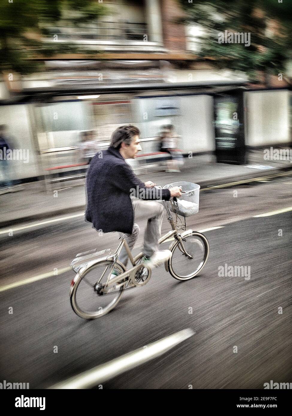 Un ciclista nel Shepherd's Bush Green di Londra (parte di una serie di immagini acquisite ed elaborate su IPhone) Foto Stock