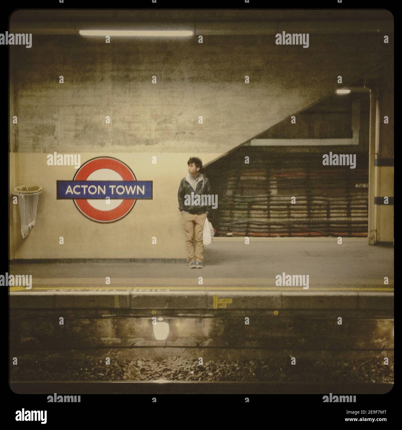 Un pendolarista attende un treno alla metropolitana di Acton Town Stazione di Londra (da una serie di immagini acquisite ed elaborate con IPhone) Foto Stock