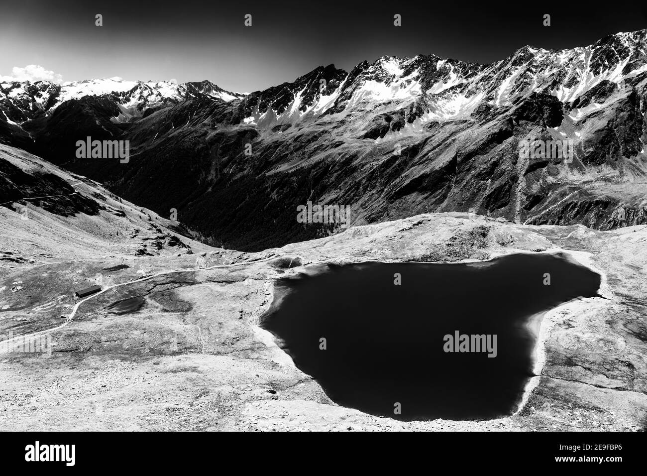 Passo Gavia, provincia di Brescia, Lombardia, Italia: Paesaggio lungo il valico estivo. Lago. Bianco e nero Foto Stock