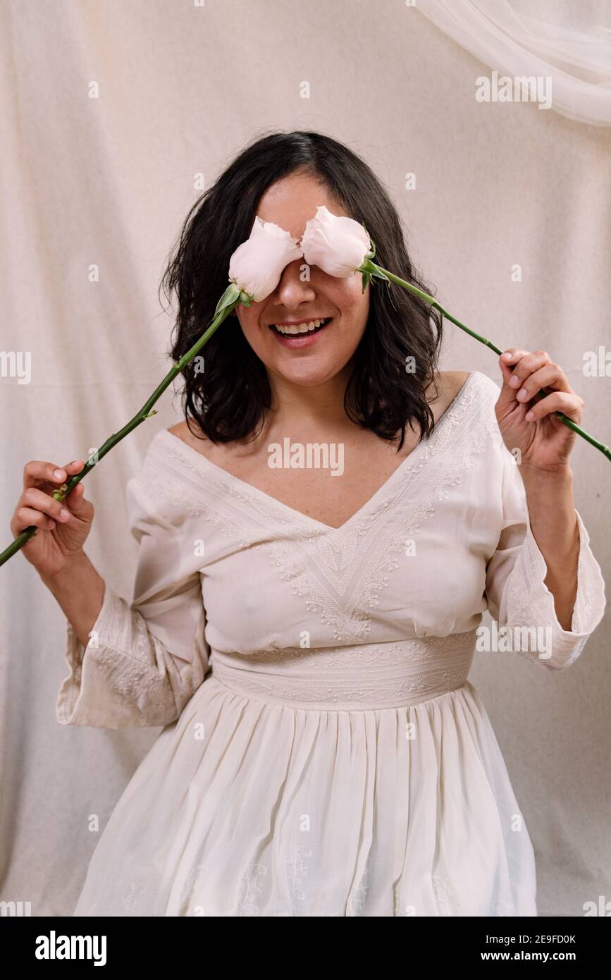 elegante ritratto da studio donna con abito bianco e delicato abito bianco e look naturale da vicino. sfondo in tessuto. sorridente e divertente Foto Stock