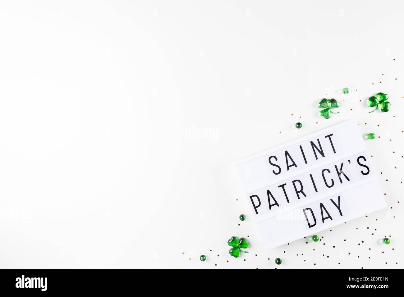 Scatola luminosa con testo di San Patrizio e sciamrocce di cuori di vetro verde Foto Stock