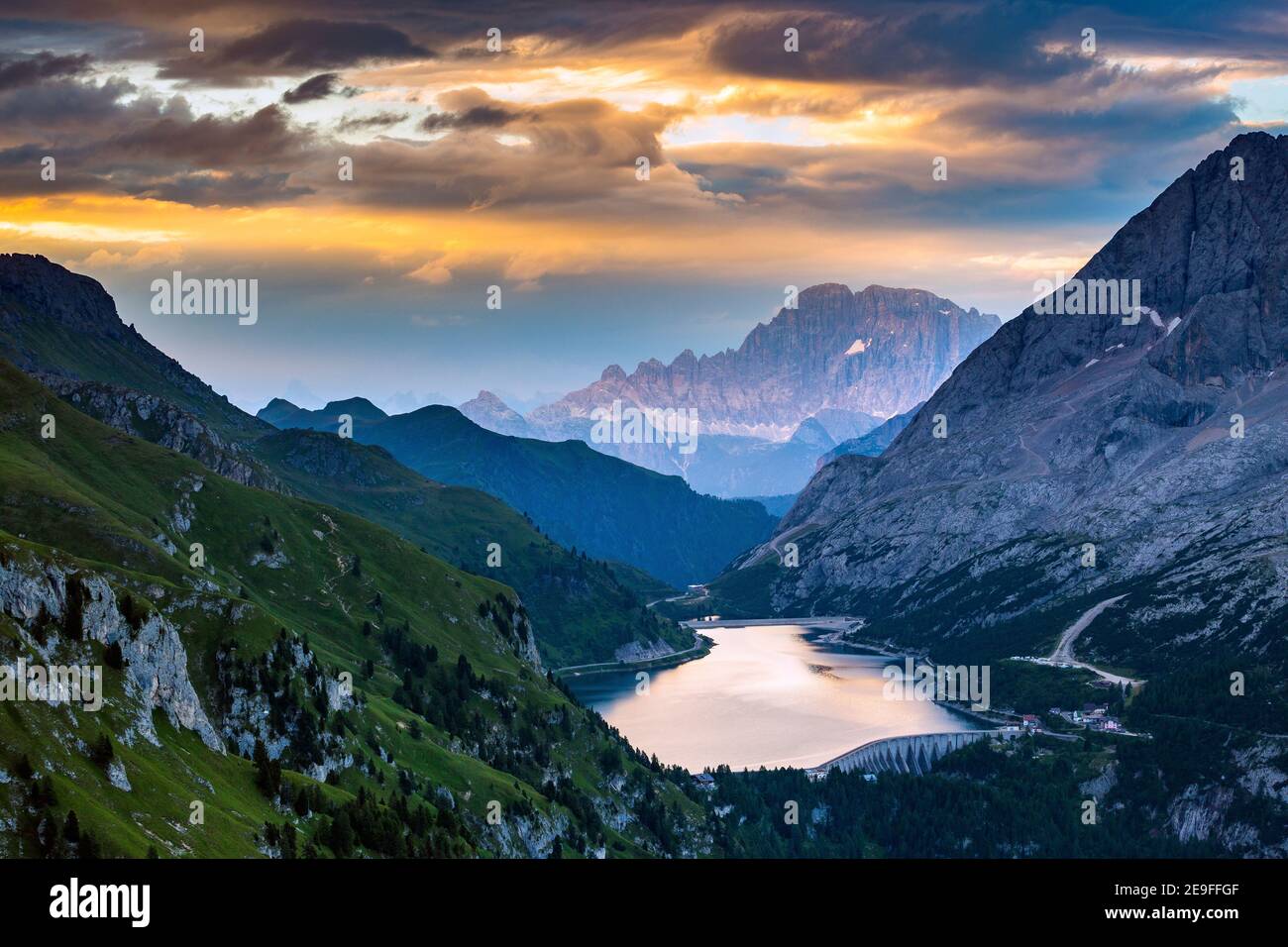 Lago Fedaia e Monte Civetta. Le Dolomiti all'alba. Luce del sole riflesso sull'acqua del lago. Alpi Italiane. Europa. Foto Stock
