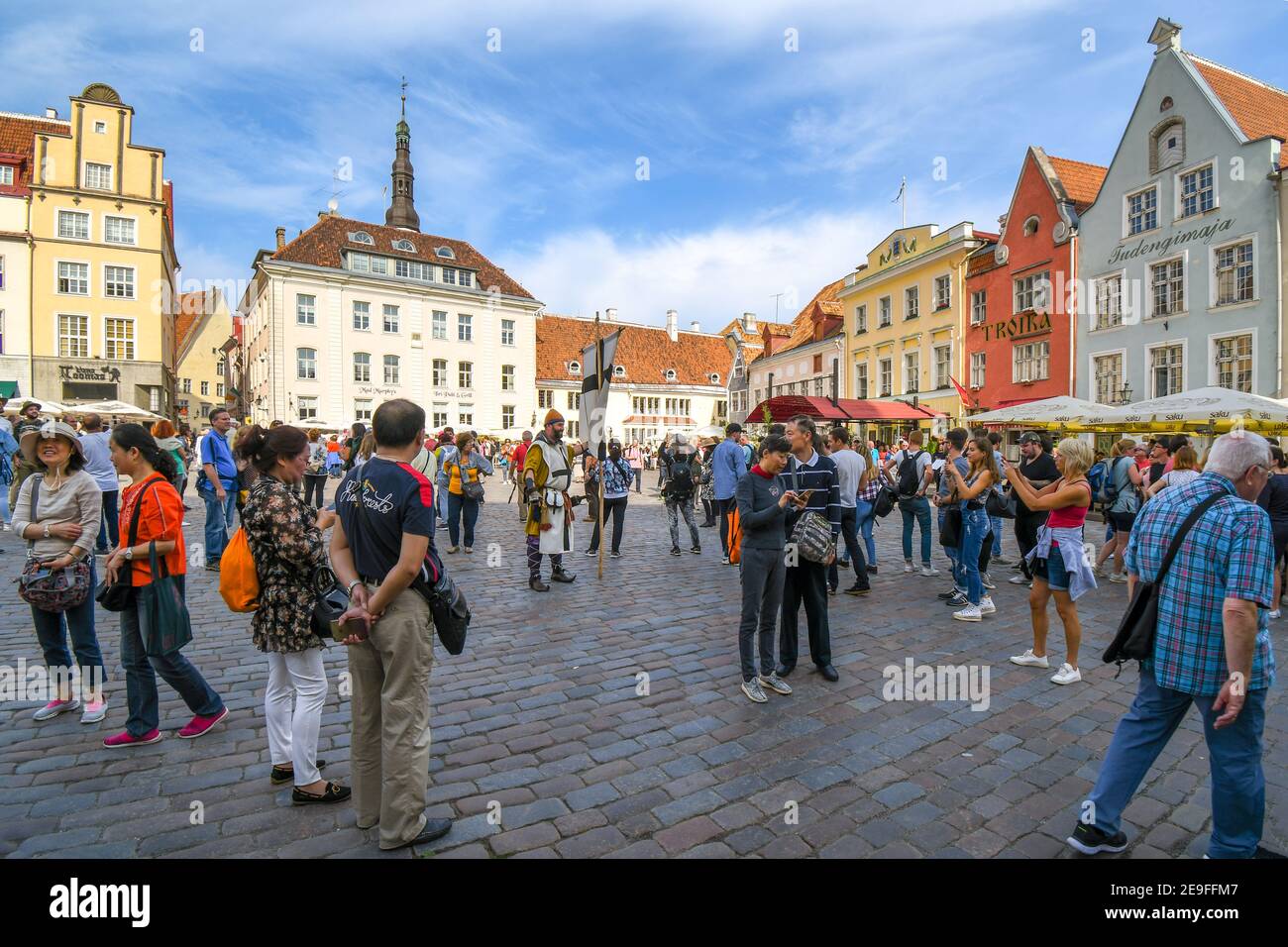 Un uomo vestito da cavaliere medievale intrattiene i turisti La piazza principale della Città Vecchia di Tallinn Estonia durante il Festival della maratona di settembre Foto Stock