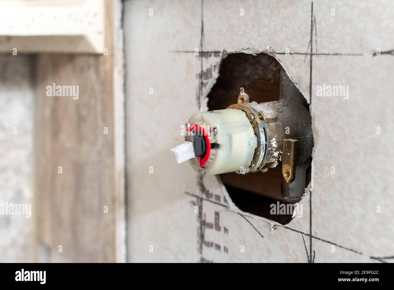 Installazione del rubinetto della doccia durante una ristrutturazione domestica di una doccia piastrellata in un bagno residenziale. Foto Stock