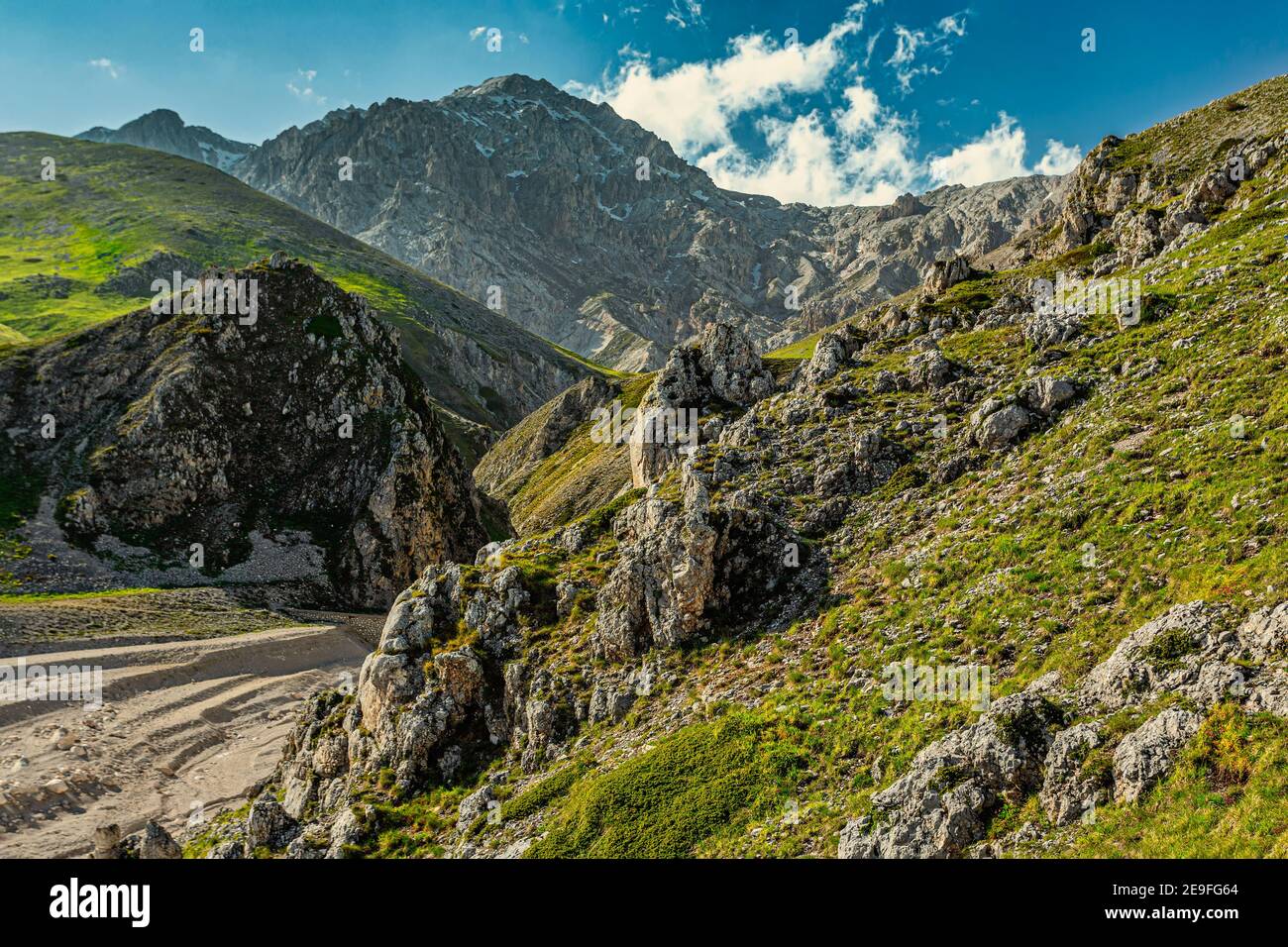 Una delle tante valli che fiancheggiano l'altopiano di campo Imperatore. Sullo sfondo il Monte Prena della catena montuosa del Gran Sasso. Foto Stock