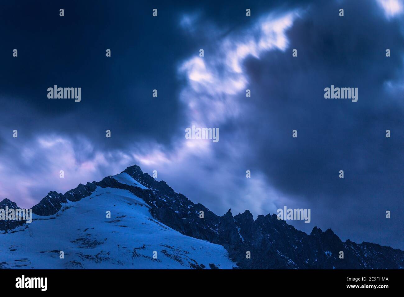 Spettacolari nuvole all'ora blu dopo il tramonto sul monte Schlieferspitze nella valle di Obersulzbach. Alpi austriache. Europa. Foto Stock