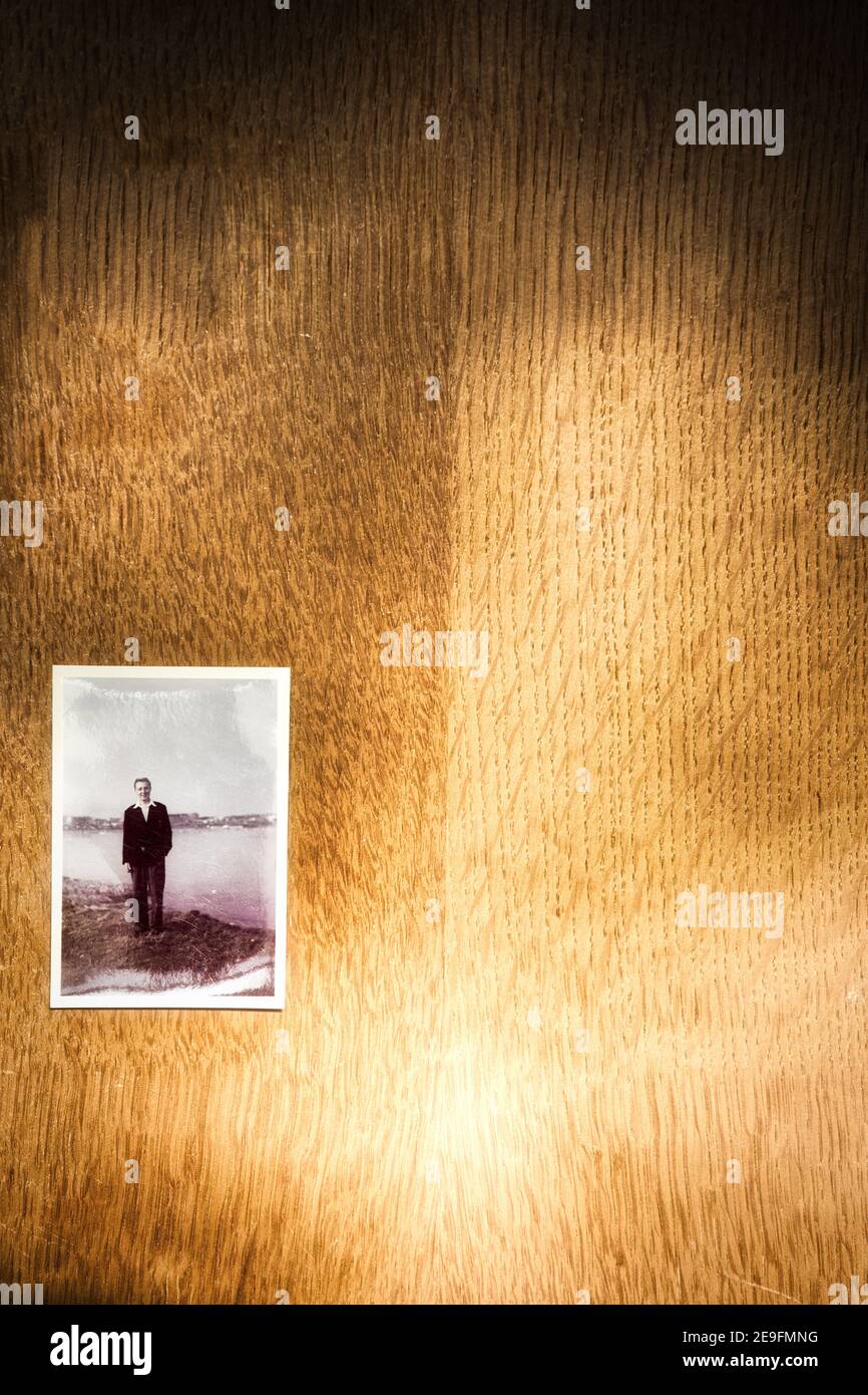 Direttamente sopra la fotografia degli anni '50 di un giovane sorridente che si trova accanto al mare su sfondo di legno. Concetto di un tempo, nostalgia, anni '50 Foto Stock