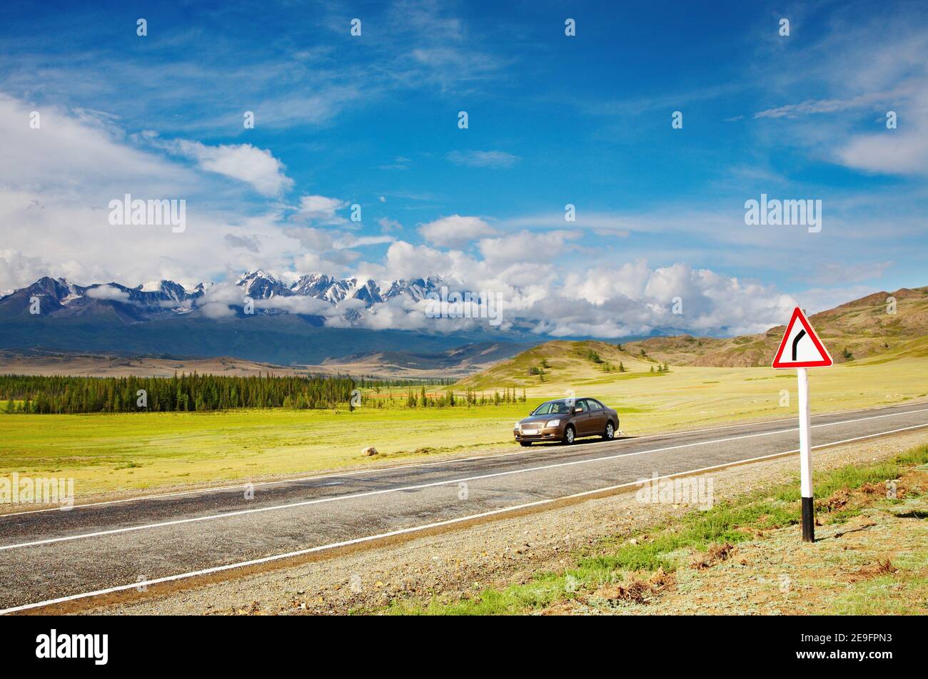 Auto a bordo strada e montagne come sfondo Foto Stock