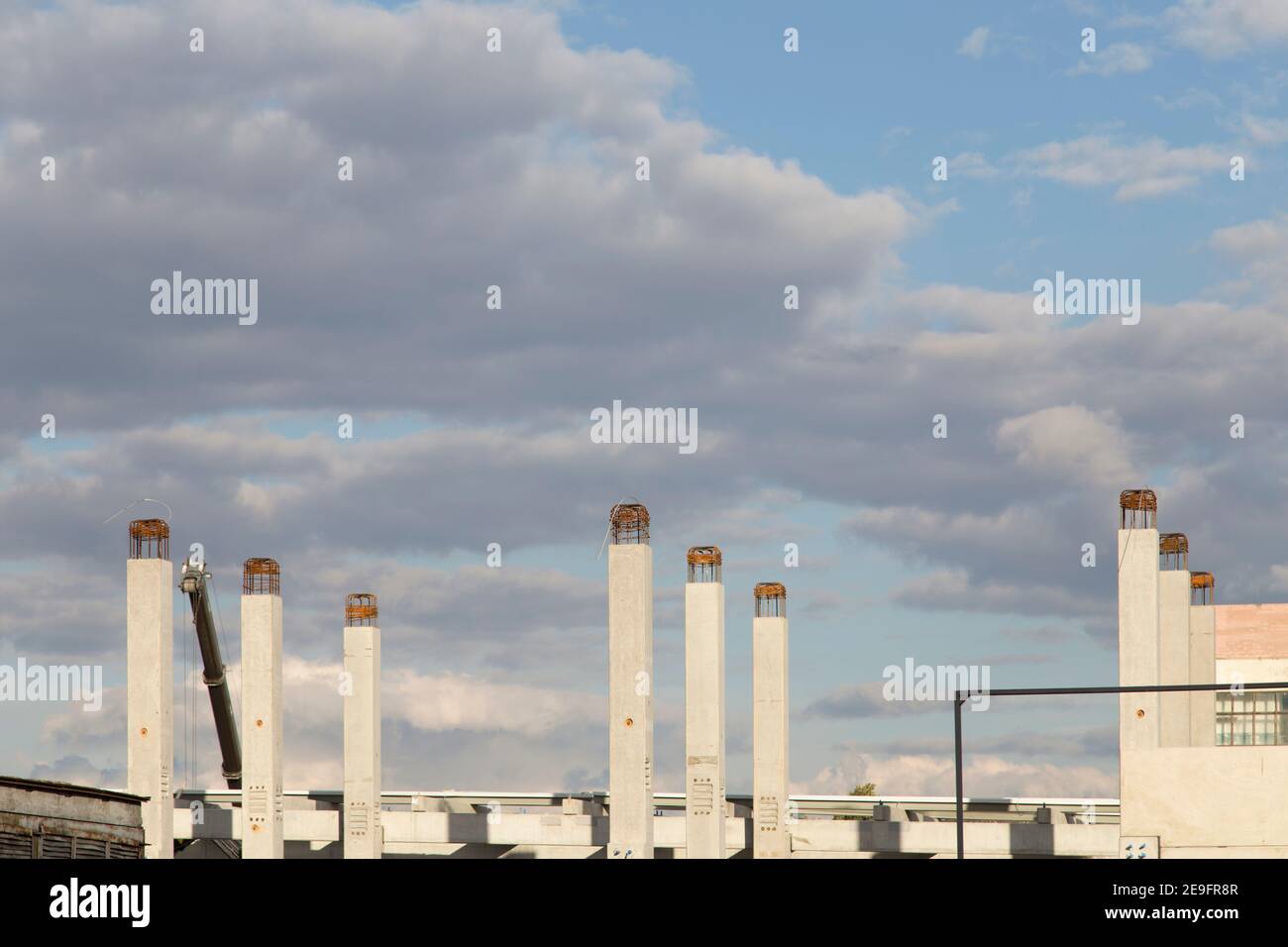 Concetto di nuova costruzione sullo sfondo del cielo blu. Le colonne stanno andando al cielo. Foto Stock