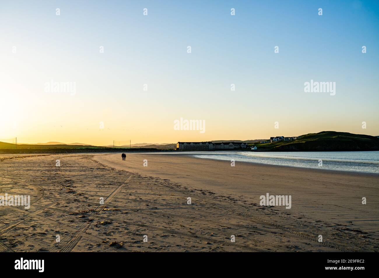 Coppia a piedi su una spiaggia di sabbia a Donegal Foto Stock