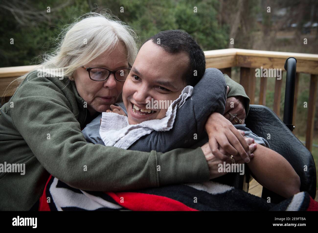 Byron, Georgia, Stati Uniti. 4 Feb 2021. LISA ARCHIBALD si prende cura del fratello John David, profondamente disabile, che si trova a casa sua da oltre 20 anni. John David, 36 anni, è non verbale, quadriplegico e medico fragile a causa della paralisi cerebrale, della policiciria e della displasia. Vive a casa ArchibaldÃs e richiede assistenza 24 ore su 24. Ha convulsioni, malattia polmonare restrittiva e aspirazione silenziosa nei suoi polmoni, che richiede una supervisione costante per prevenire soffocamento.Archibald è stato in grado di prendersi cura di suo fratello nella sua casa con l'aiuto di un patchwork di personale di supporto, finanziato da una rinuncia Medicaid Foto Stock