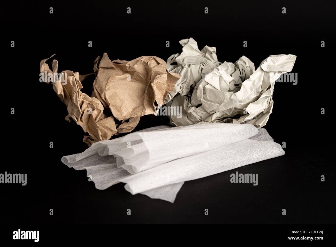 Materiale di imballaggio per la spedizione su sfondo scuro. Confezioni diverse, come carta riciclata e fogli in schiuma di plastica, per avvolgere qualcosa Foto Stock