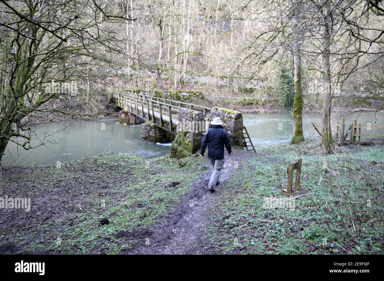 Walker sta per attraversare la passerella a Litton Mill in Derbyshire Foto Stock