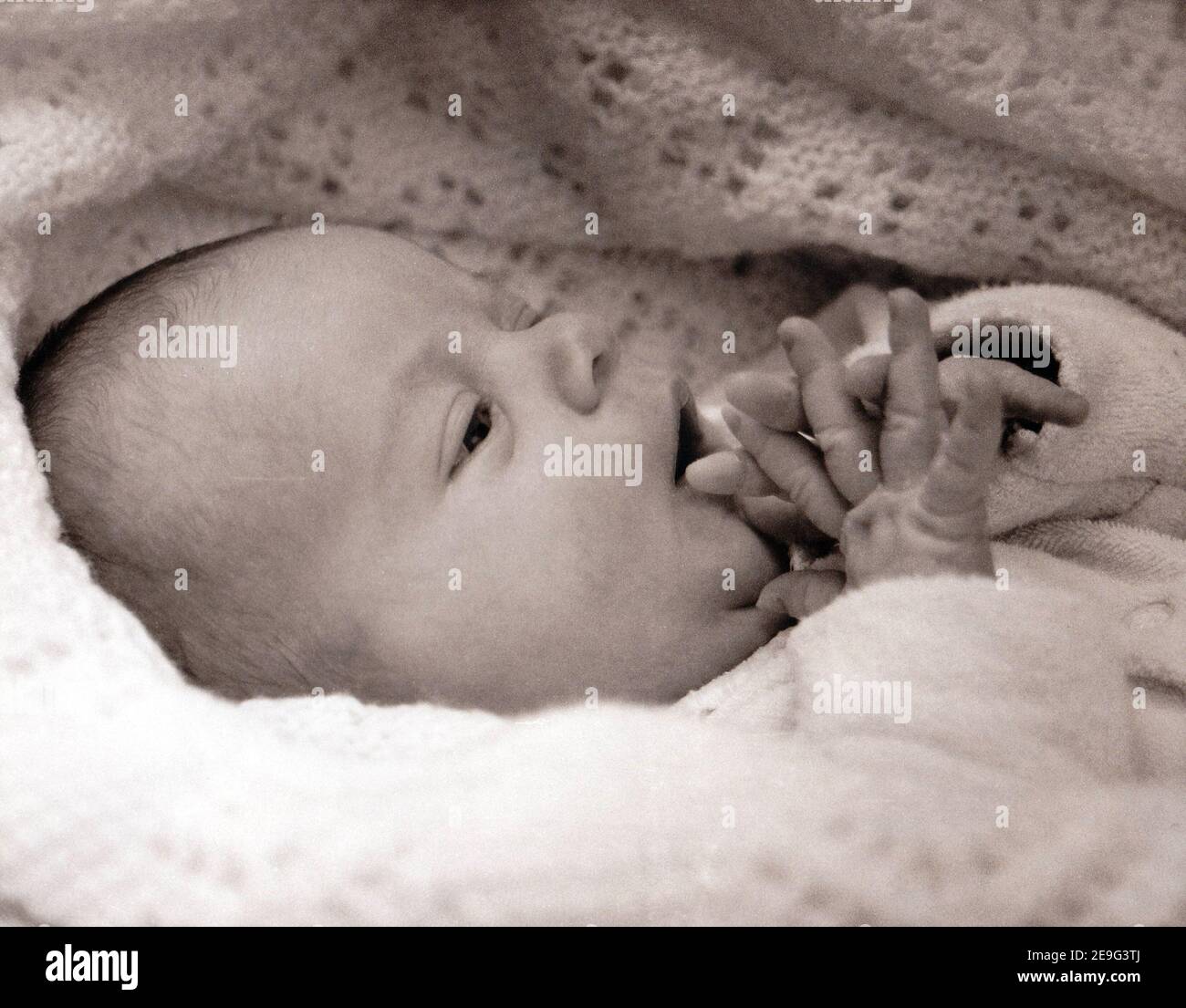 neonato avvolto in coperta scansionata da stampa monocromatica Foto Stock