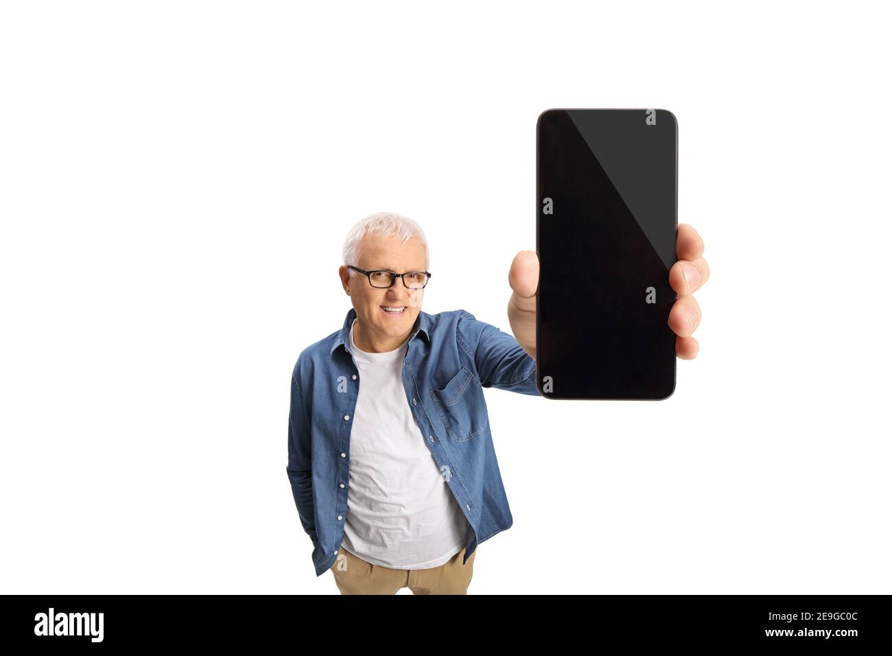 Uomo maturo sorridente che mostra uno schermo del telefono cellulare isolato sfondo bianco Foto Stock