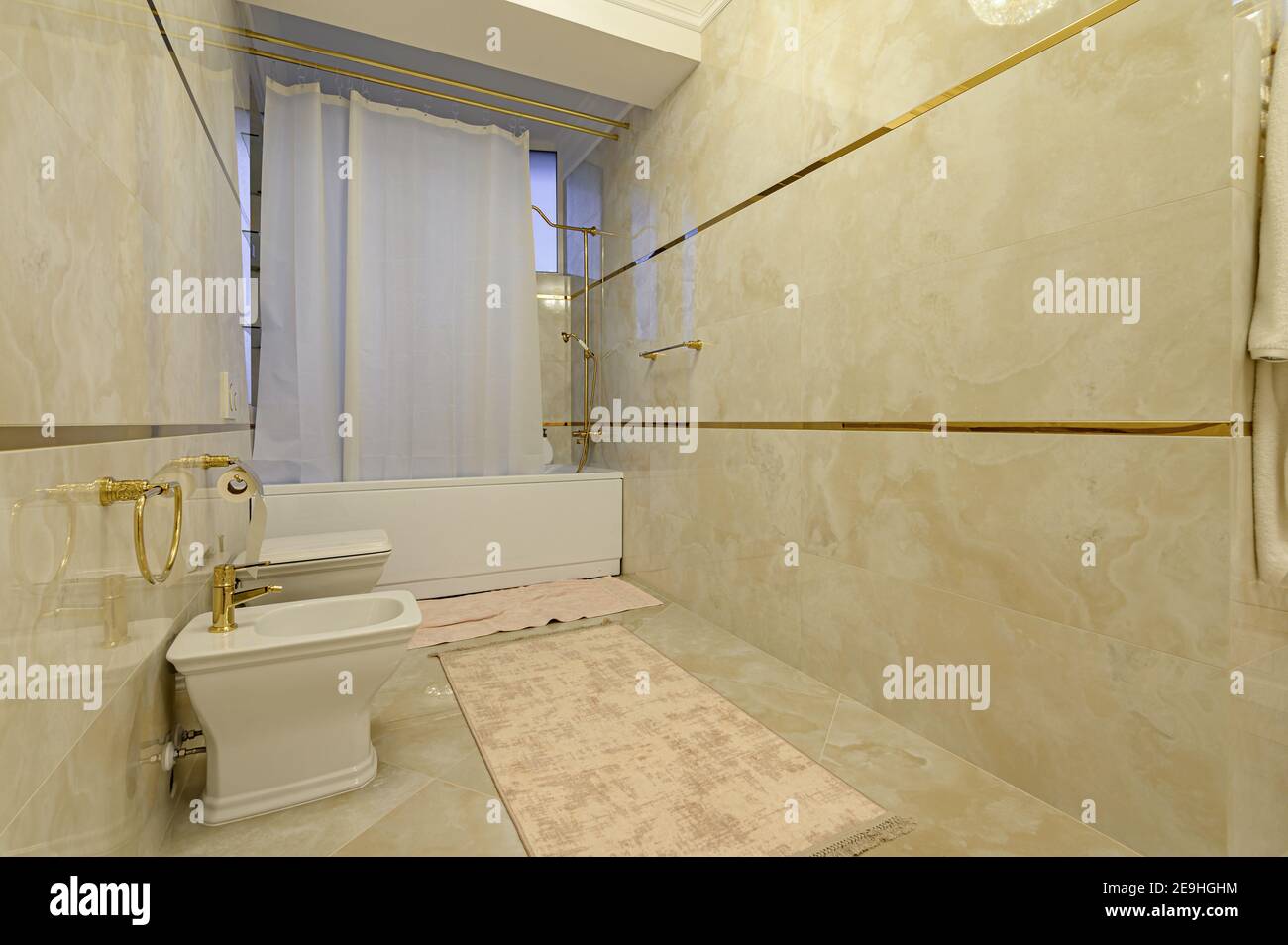 Moderno e lussuoso bagno beige e dorato con toilet Foto Stock