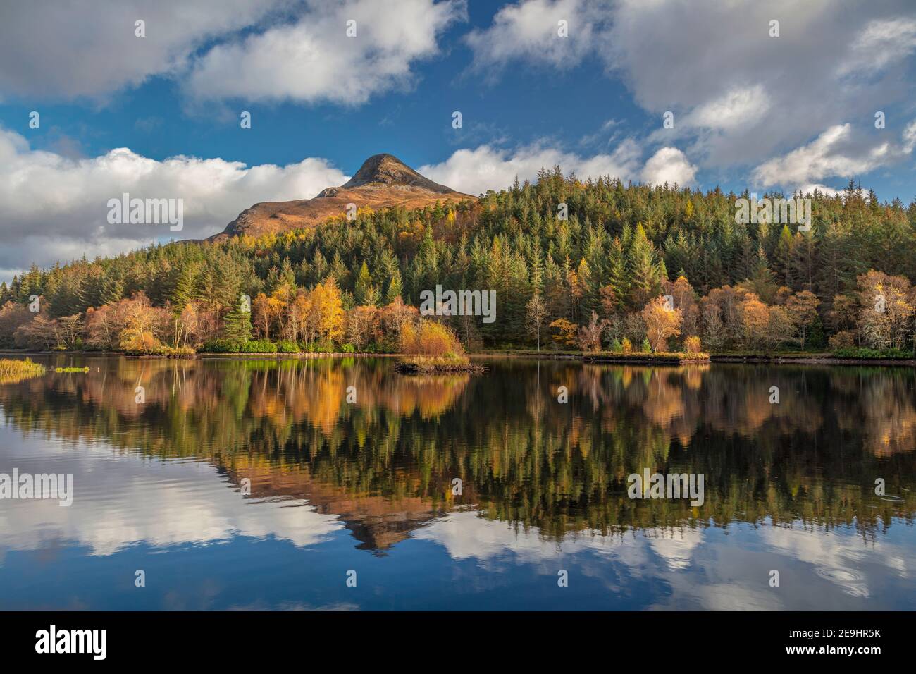 Glencoe, Scozia: Glencoe Lochan con riflessi autunnali e il Pap in lontananza Foto Stock