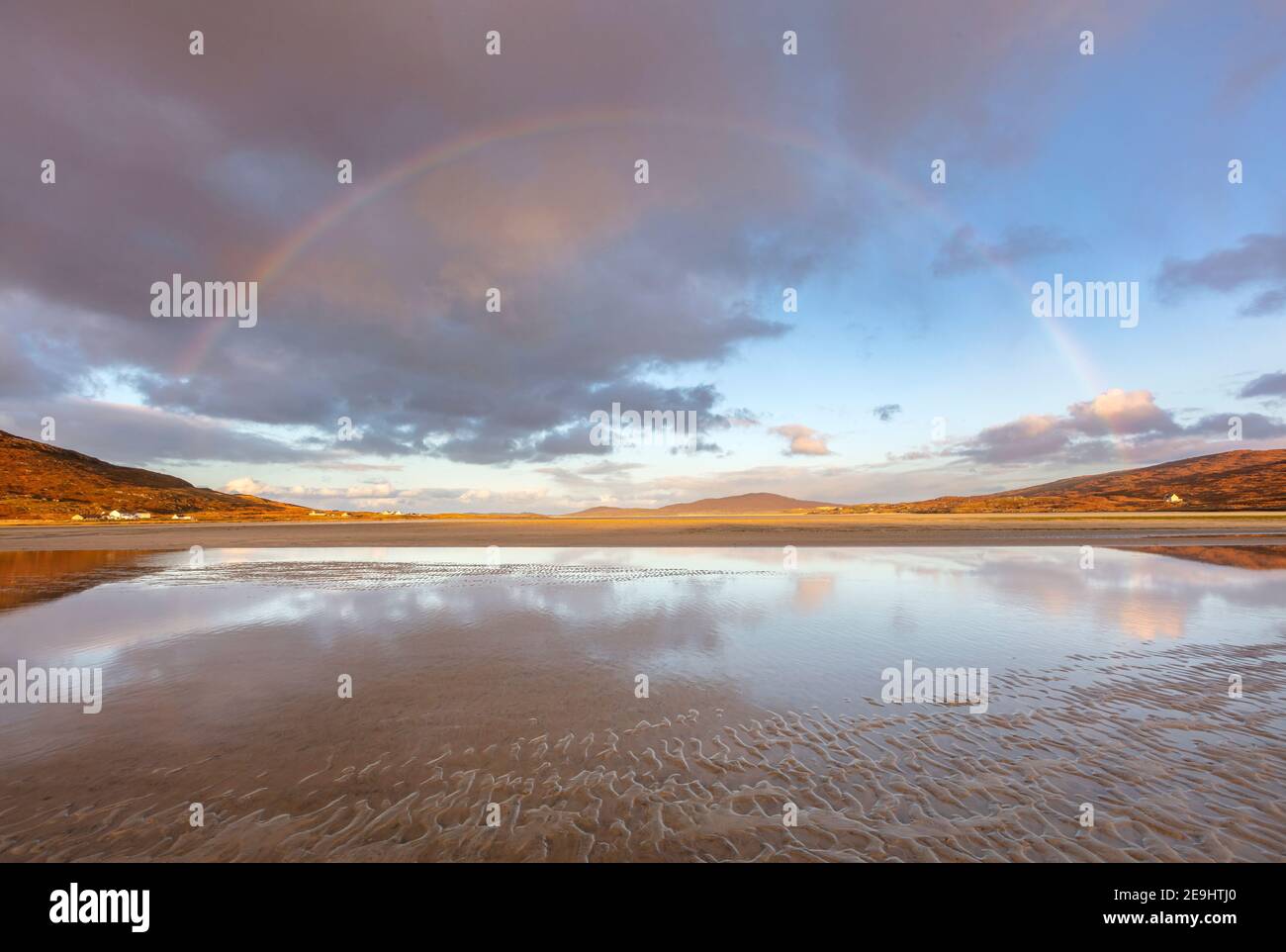 Isola di Lewis e Harris, Scozia: Un arcobaleno si estende sull'ampia baia di sabbia di Luskentire sulla South Harris Island Foto Stock